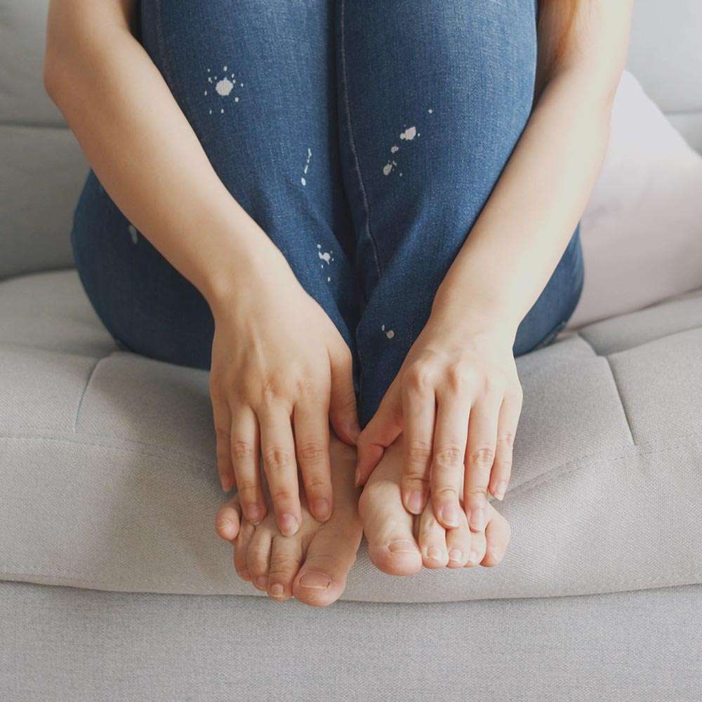 Sitting on sofa with bare feet and jeans